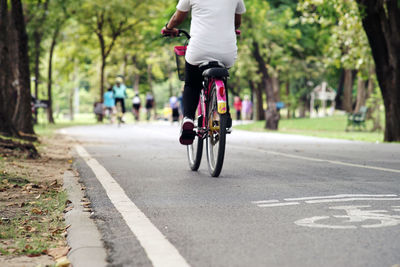 Low section of person riding bicycle on road