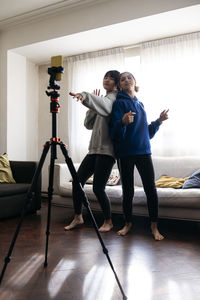 Friends filming dance through mobile phone at home