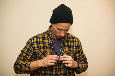 Young man looking away against white background