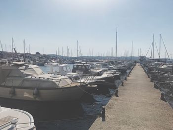 Sailboats moored at harbor