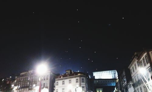 Low angle view of illuminated buildings against sky at night