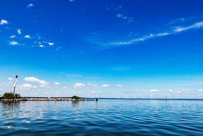 Swimming pool by sea against blue sky