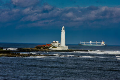 Tankers passes behind the lighthouse on st. mary's island, whitley bay, england