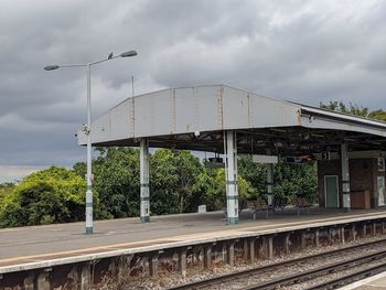 Railroad tracks by bridge against sky