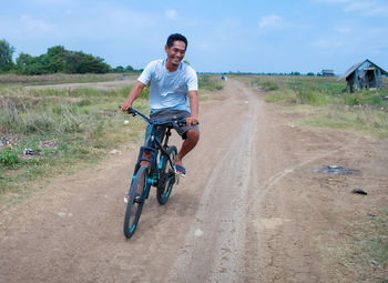 Portrait of man riding bicycle on road