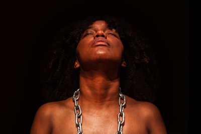 Low angle view of woman standing against black background