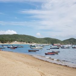 Boats moored on beach against sky
