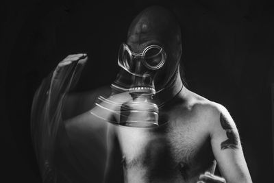 Blurred motion of man wearing gas mask in darkroom