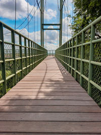 View of wooden footbridge against sky