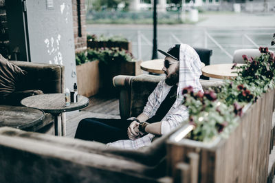 Young man sitting on sofa at restaurant