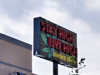 Low angle view of information sign against sky
