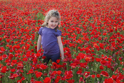 Portrait of a smiling young woman with red flowers