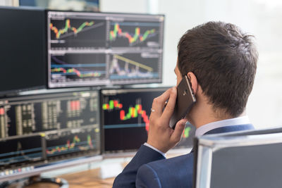 Businessman talking on phone while sitting in office