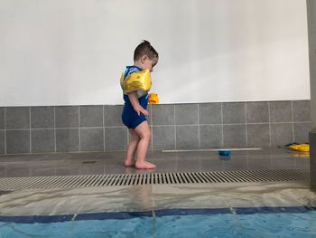 Side view of boy standing on poolside