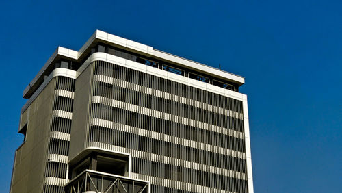 Low angle view of modern building against clear blue sky