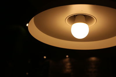 Low angle view of illuminated light bulb against sky at night