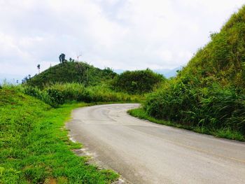 Road amidst trees against sky