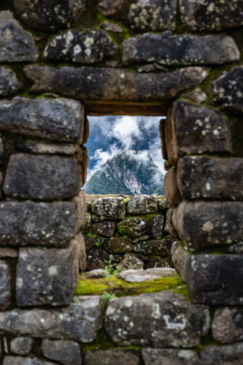 VIEW OF STONE WALL WITH OLD RUIN AND BRICK WALLS