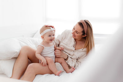 Happy mother and baby on bed