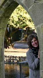 Portrait of smiling woman standing by water