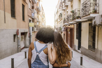 Rear view of female friends standing in city