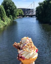 Close-up of ice cream over river against sky