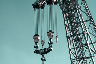 Low angle view of chain swing ride against sky