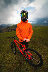 Wide angle vertical frame top angle. portrait of a bearded mountain biker with his bicycle against a
