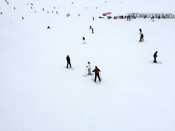 High angle view of people skiing on snowy field