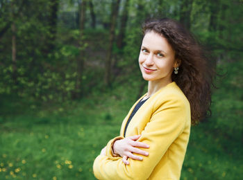 Portrait of smiling young woman standing in forest