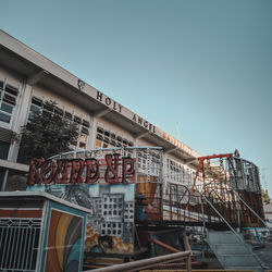 Low angle view of text on building against clear sky