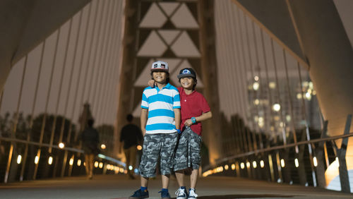 Two children on bridge at night