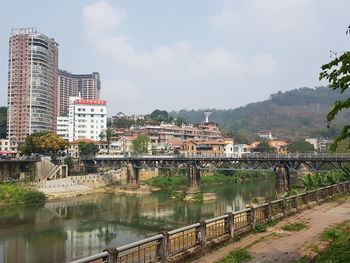 River by cityscape against sky