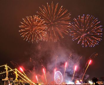 Low angle view of firework display at night