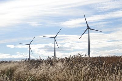 Windmill on field against sky