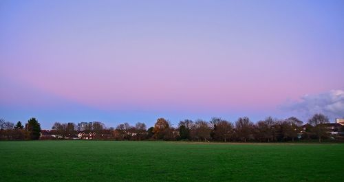 Scenic view of grassy field against cloudy sky