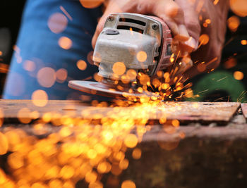 Midsection of man cutting metal