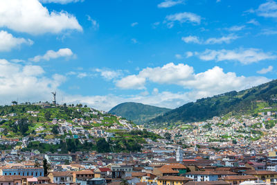 Buildings against cloudy blue sky on sunny day in city