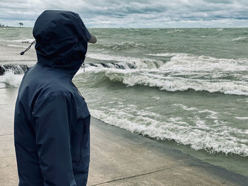 Rear view of man looking at sea shore