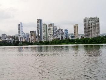 River by buildings against sky in city