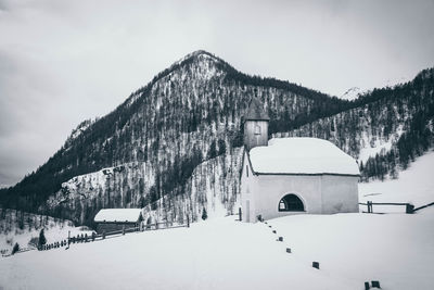 Built structure on snow covered mountain against sky