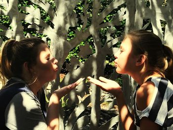 Side view of mother and daughter outdoors