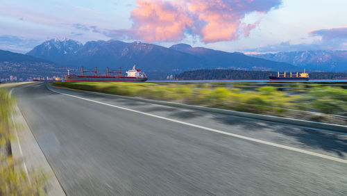 Road leading towards mountains against sky