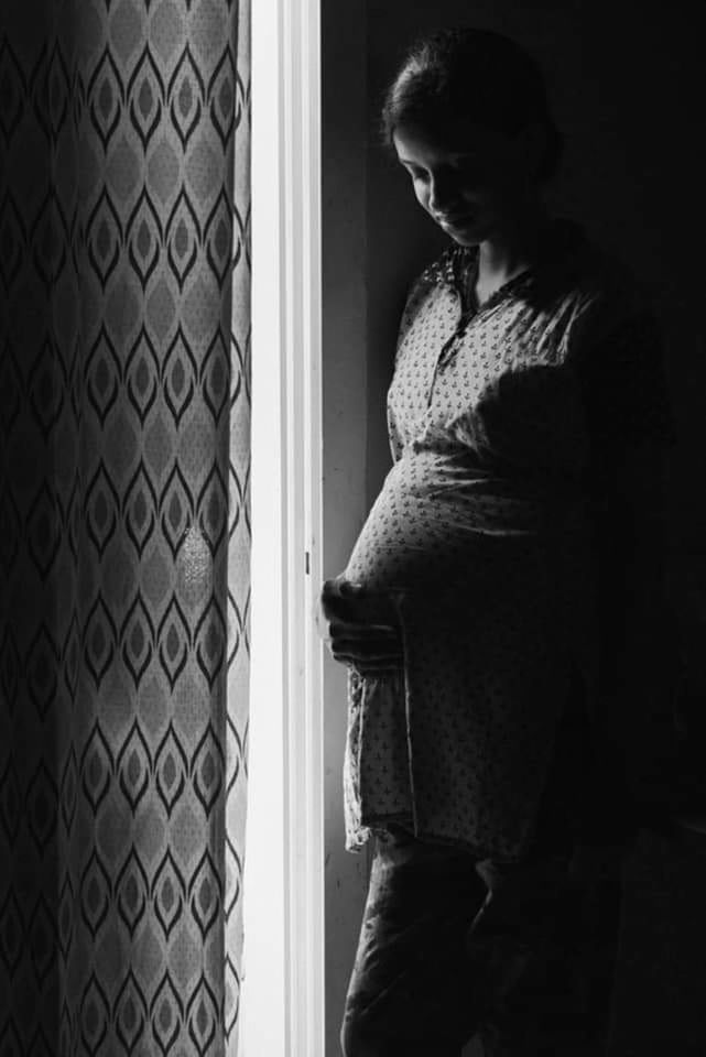 black, black and white, white, one person, monochrome photography, indoors, adult, women, pregnant, monochrome, standing, darkness, anticipation, three quarter length, window, lifestyles, female, looking, side view, emotion, casual clothing, child, young adult, parent, home interior, dress, person, entrance, door, light, clothing, waist up, beginnings, contemplation