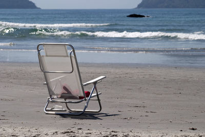 Chairs on beach against sea