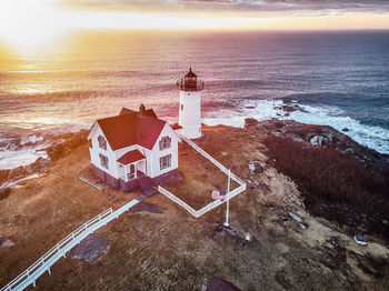 High angle view of lighthouse on beach by sea against sky