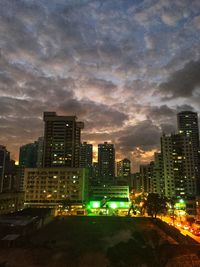 Illuminated buildings in city against sky at night