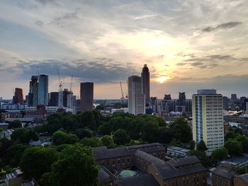 Modern buildings against sky during sunset