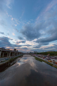 Bridge over river in city against sky