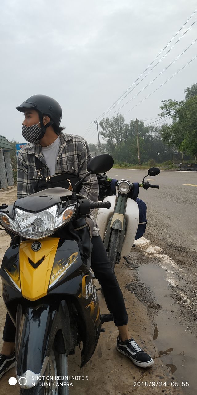 WOMAN RIDING MOTORCYCLE ON ROAD